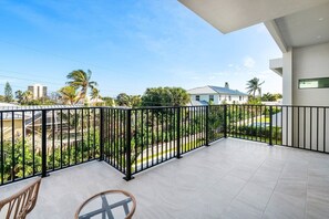 A balcony with a view of a residential area, including houses and palm trees.