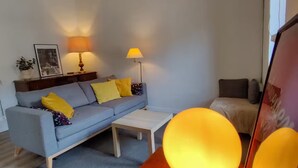 Un salon moderne avec un canapé, deux lampes, une table basse et un plancher en bois.