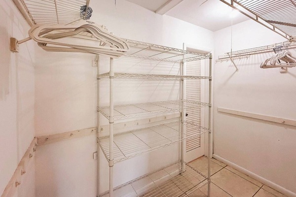 Organized walk-in closet with built-in shelving & ample storage.