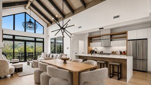 Una cocina moderna con una isla grande, electrodomésticos de acero inoxidable y vistas al exterior.