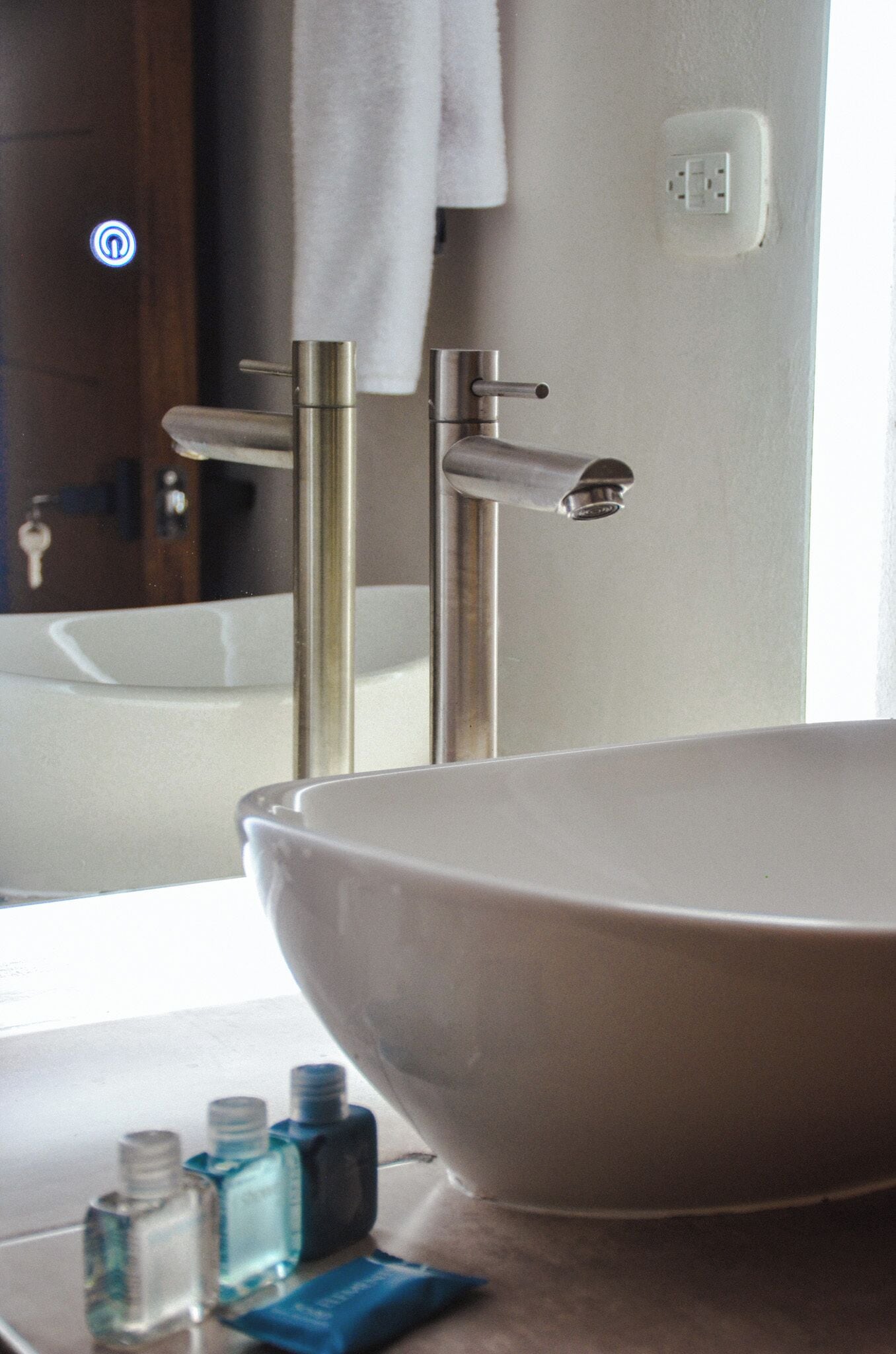Un baño con un lavabo blanco grande, un espejo y una toalla colgada en la pared.