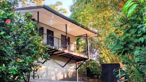 A modern house with a balcony, surrounded by lush greenery. - Fully Equipped Kitchen Privacy & Pura Vida (Quepos)