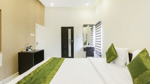 Une chambre d’hôtel avec un lit, un bureau et une armoire.