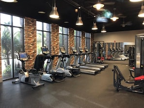 A gym with treadmills, elliptical machines, and weight equipment.
