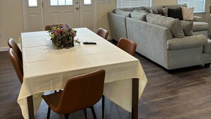 A dining area with a table, chairs, and a vase of flowers.