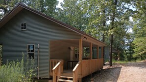 A two-story cabin with a covered porch and a small front porch.