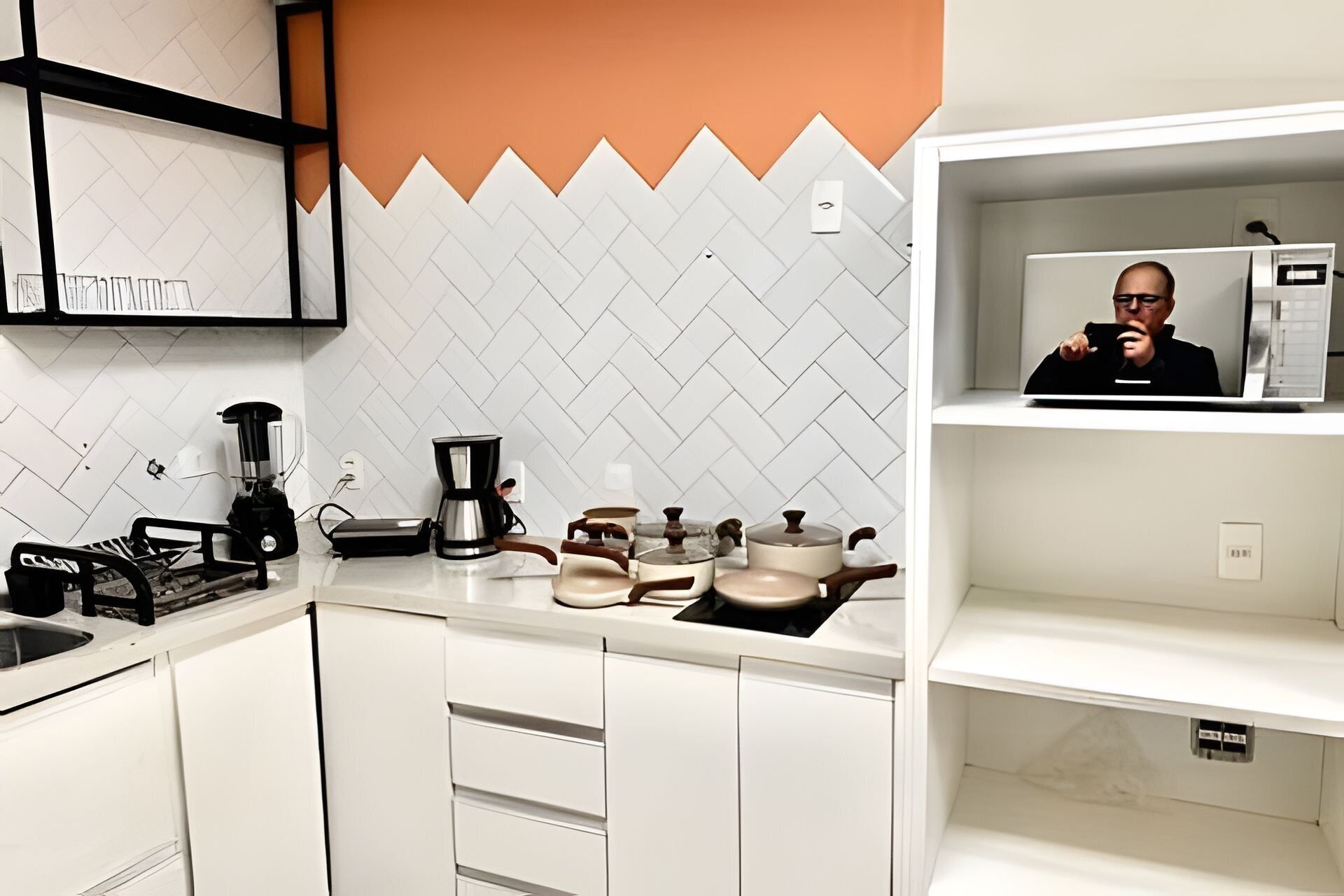 Una cocina moderna con armarios blancos, una cafetera y un hervidor en la encimera.