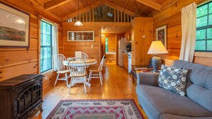 Een gezellig chalet van binnen met een eethoek, keuken en woonkamer.