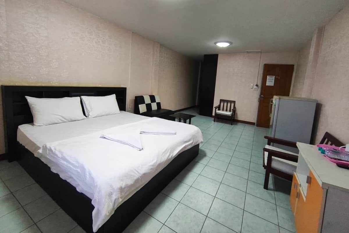 Habitación de hotel con cama, escritorio, silla y televisor.