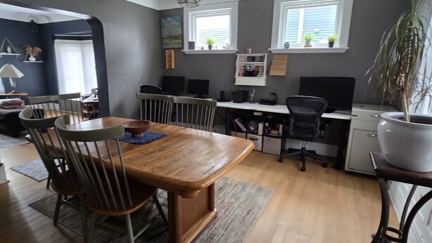 A modern kitchen with a wooden dining table, chairs, and a built-in stove. - Spacious 4-bedroom Historic house with WiFi in heart of Detroit/Free Parking! (Detroit)