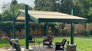 A covered patio area with outdoor furniture and a brick base. - Spacious 4-bedroom Historic house with WiFi in heart of Detroit/Free Parking! (Detroit)