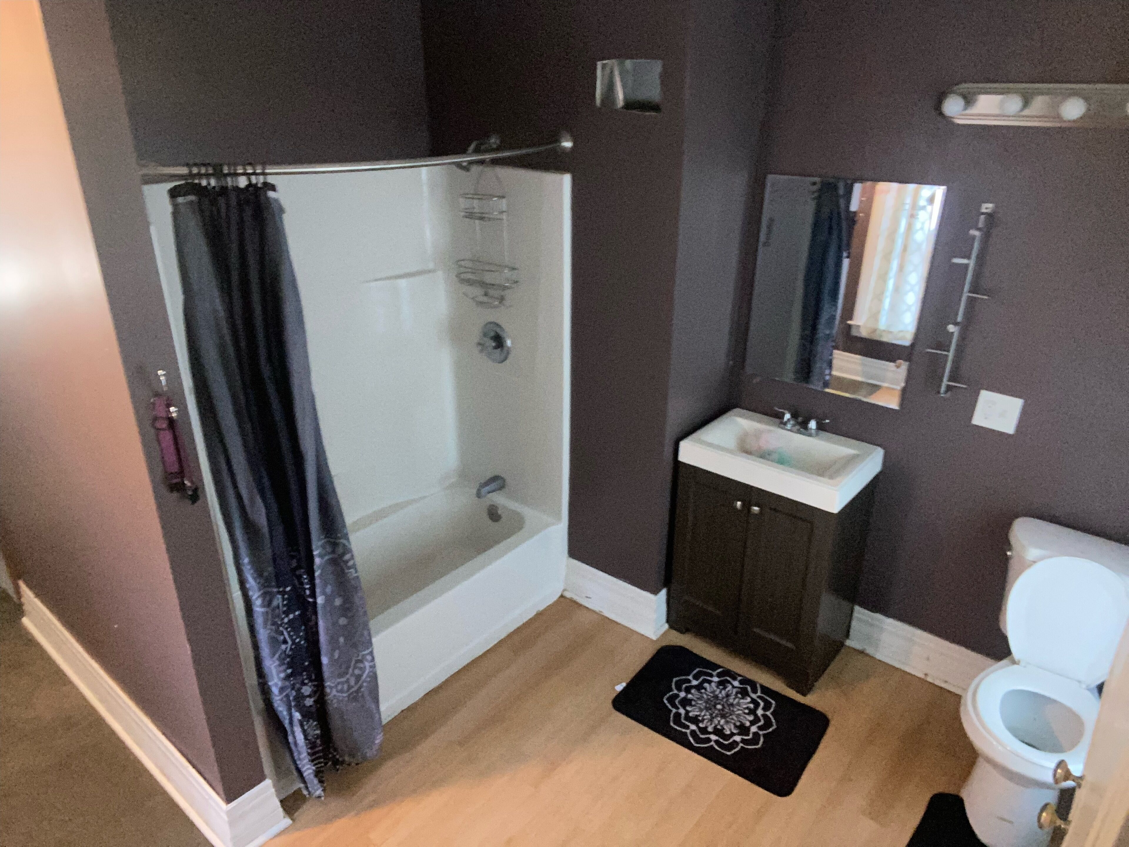 Een badkamer met douche, wastafel en toilet.