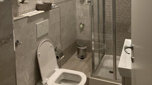 Une salle de bain moderne avec des toilettes, une douche à parois de verre et un lavabo.