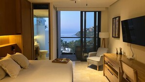 Un dormitorio moderno con una cama grande, un escritorio, una silla y un televisor.