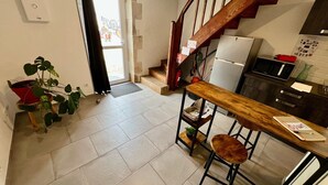 A kitchen with a wooden table, a refrigerator, and a microwave.
