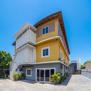 A multi-story building with a balcony, a garage, and potted plants. - Incognito Vacation Stays (Kingston)
