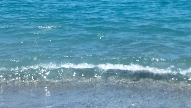 Visão nítida de uma praia com ondas quebrando na costa.