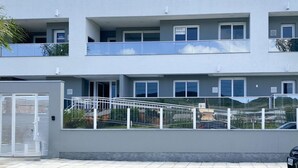 Un immeuble à plusieurs étages doté de balcons, d’une entrée sécurisée et offrant une vue dégagée sur les environs.