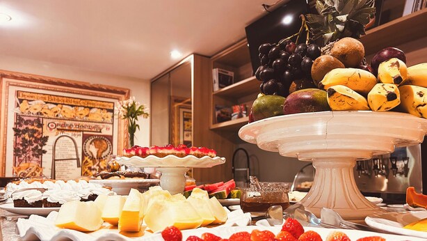 A buffet with various food items including fruits, cheeses, and desserts.