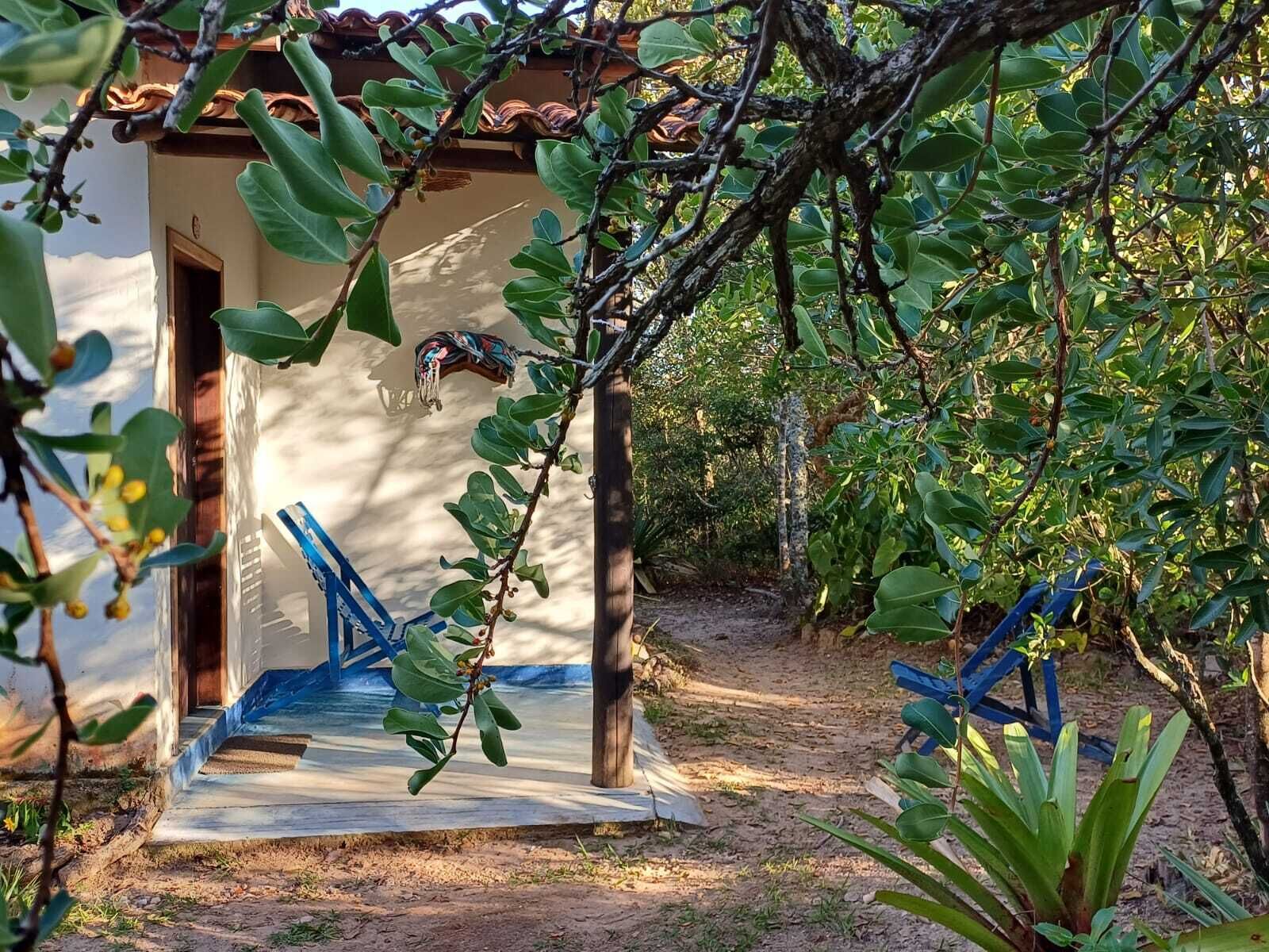 Un bâtiment rustique avec un toit en tuiles, une porte en bois et un escalier en béton menant à un porche abrité.