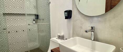 A modern bathroom with a shower, toilet, and sink.