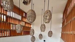 Una escalera con barandillas de madera y lámparas colgantes tejidas.