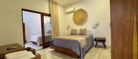 Un dormitorio con cama, armario, mesita de noche, lámpara y ventilador de techo.