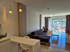 Departamento Deluxe, balcón, vista a la ciudad | Área de sala de estar | Televisión LCD de 42 pulgadas con canales digitales 