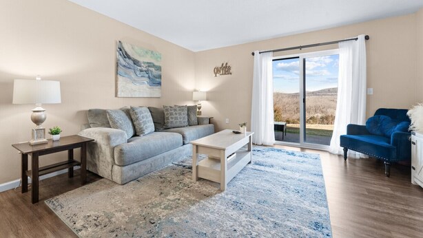Ein Wohnzimmer mit einer Couch, einem Couchtisch und Blick durch eine Schiebetür.