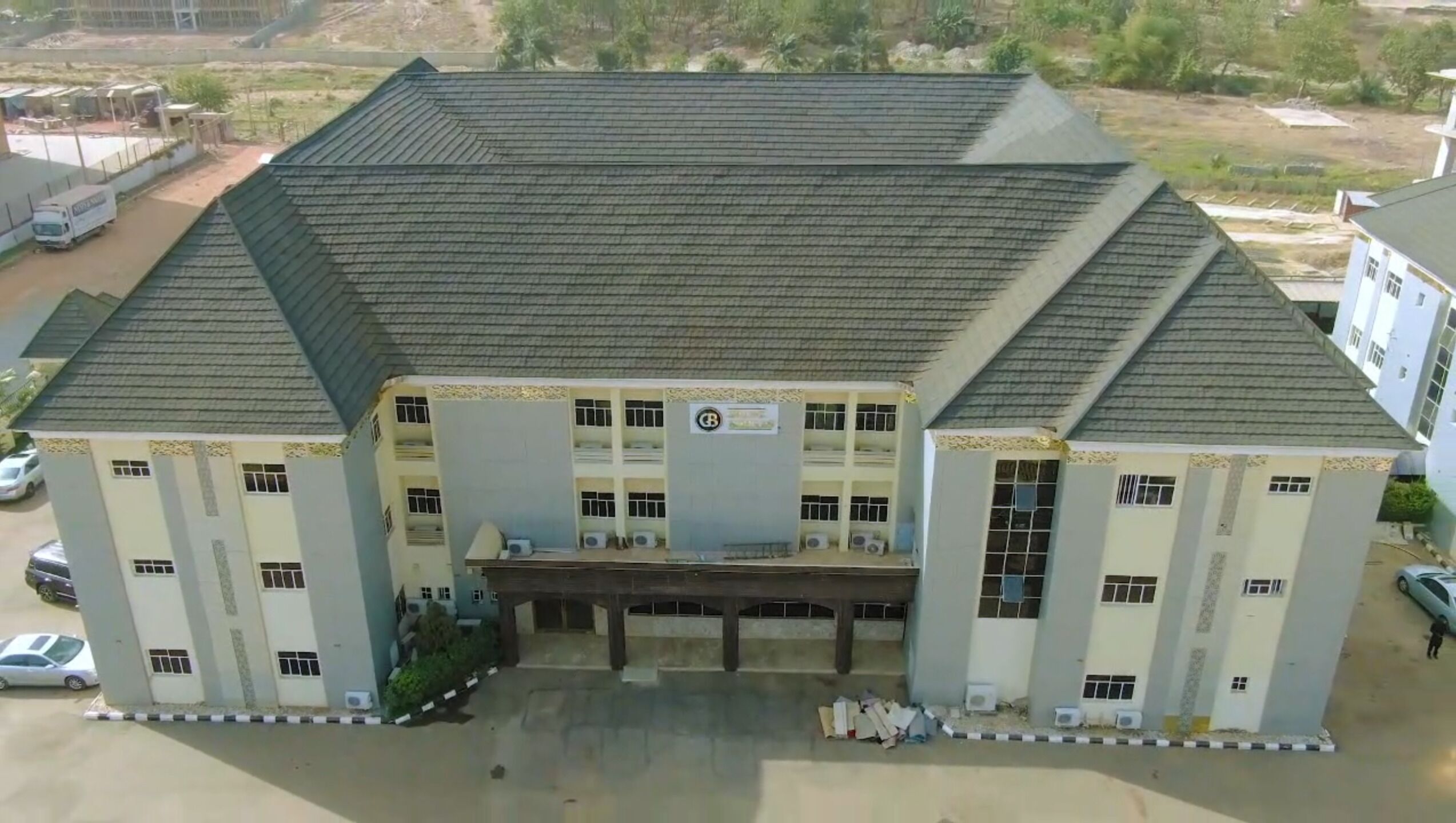 A large, multi-story building with a flat roof and a central entrance.
