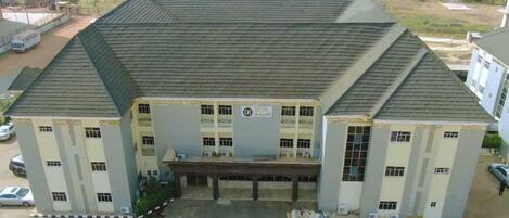 A large, multi-story building with a flat roof and a central entrance.