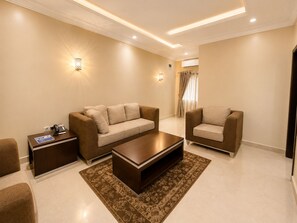 A modern living room with a sofa, a coffee table, and a side table with a phone.