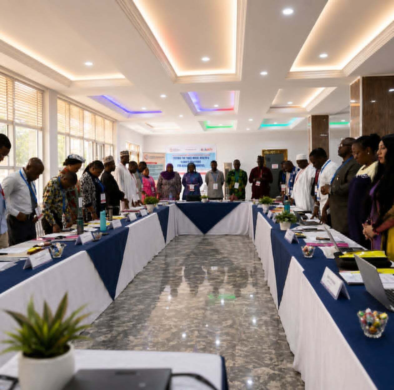 A conference room with a long table, nameplates, and attendees.