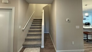 A staircase with carpeted steps leading to a landing. - SPNC Unit 101 (Fargo)