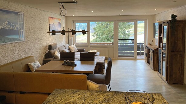 A modern living room with a dining area, large windows, and a view of the outdoors. - "Bergnest", Oberstaufen/Steibis (Oberstaufen)