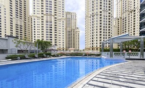 Relax by the rectangular pool surrounded by a tiled deck and lounge chairs.