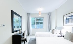 Relax in a spacious room with a large bed, desk, and mirror.