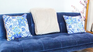 A blue sofa with patterned pillows and a beige throw blanket. - Parguera Beach Club Hotel (Lajas)