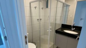 A modern bathroom with a glass-enclosed shower, a white toilet, and a black countertop sink. - Edificio Promenade II Apt 1108 (Maceio)