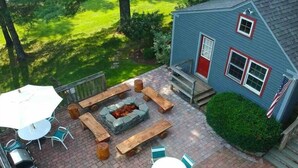 A patio with a fire pit, outdoor seating, and a flag. - 6BR 3BA - MT SNOW, SKIBACK TRAIL, FREE SHUTTLE, POOL, BBQ - Green Mountain House (Dover)