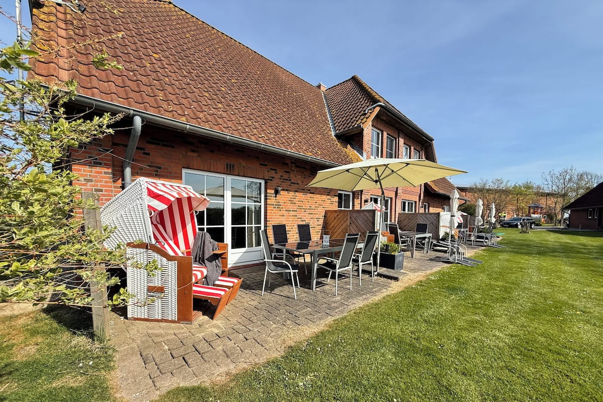 A patio area with outdoor furniture, a brick building, and a clear sky.