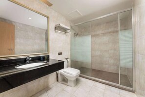 A modern bathroom with a large mirror, a black countertop, a white sink, and a glass shower enclosure. - Joy Hotel (Foshan Nanhai Pengruili Jihua Plaza) (Foshan)
