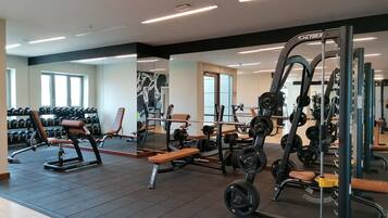 Een sportschool met gewichthefapparatuur, banken en halters.