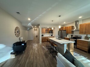 Une cuisine moderne avec des meubles en bois, des appareils en acier inoxydable et un îlot central.