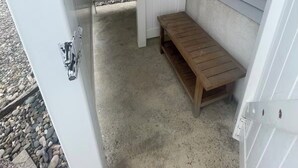 A small, enclosed outdoor area with a wooden bench, a white door, and a white fence. - Charming 3-bedroom condo with AC, WiFi in brilliant Wildwood Crest (Wildwood Crest)