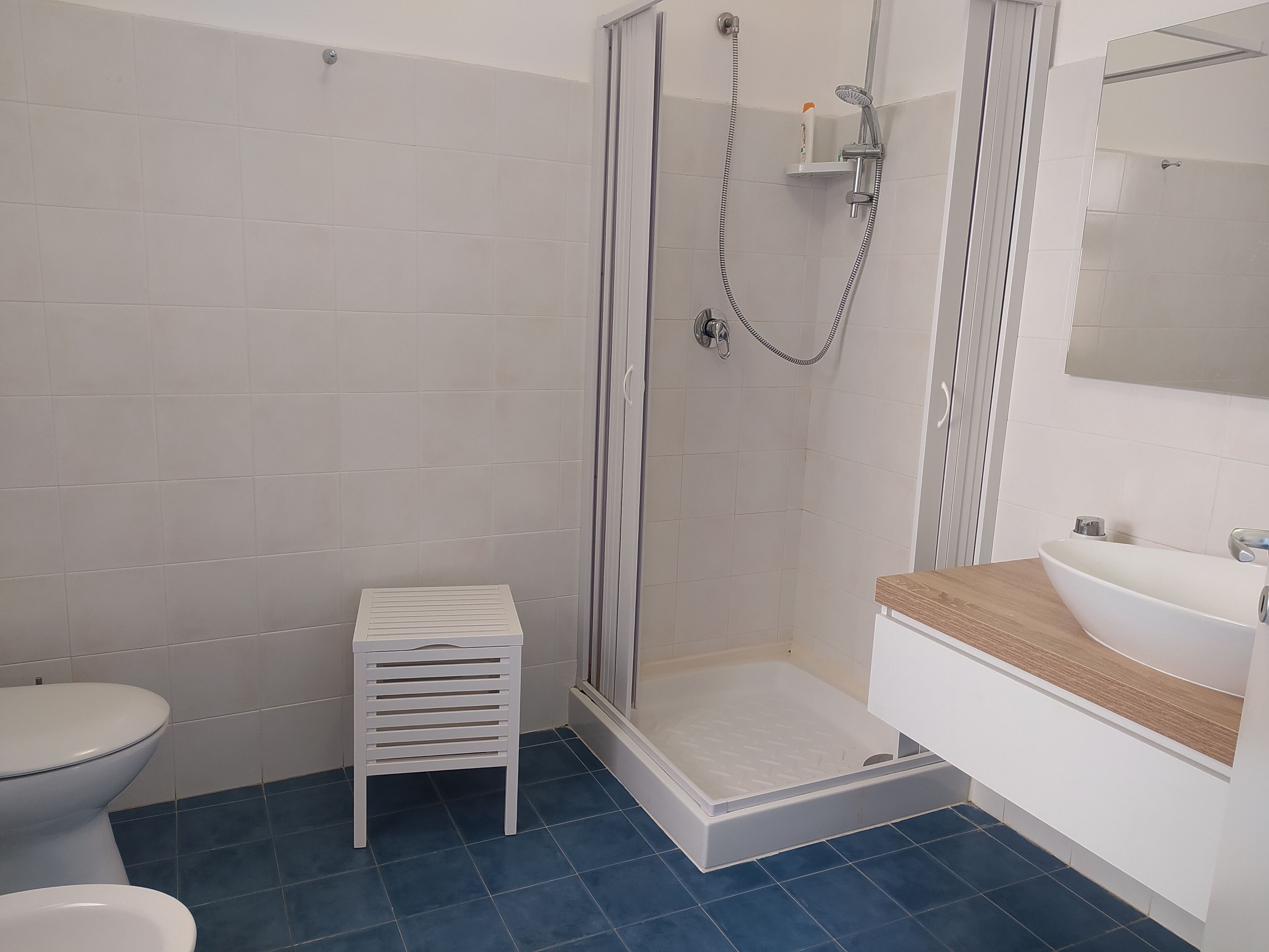 A bathroom with a shower, toilet, and sink.