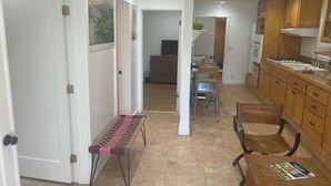 A spacious kitchen with wooden cabinets, a dining area with chairs, and a bench.