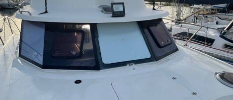 A boat's bow with a cabin structure, windows, and a small control panel.