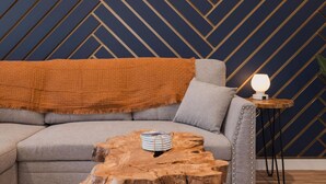 Una sala de estar moderna con un sofá, una mesa de centro de madera y una lámpara.