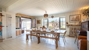 A spacious dining area with a large wooden table, benches, and a rustic ceiling. - Camber Beach House - Five Bedroom Villa, Sleeps 10 (Camber)